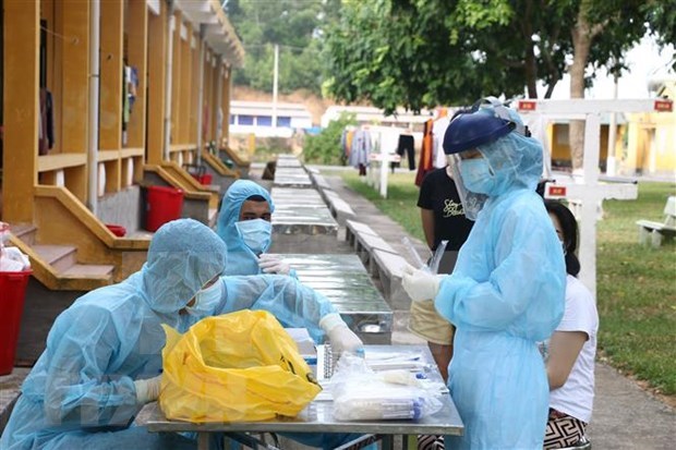 Medical workers take samples for COVID-19 testing at a quarantine facility in Vietnam. (Photo: VNA)