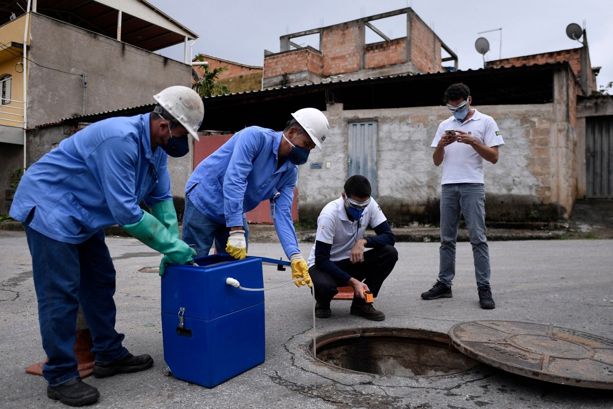 Các nhà nghiên cứu thu thập mẫu nước thải tại Belo Horizonte, Brazil. Ảnh: AFP