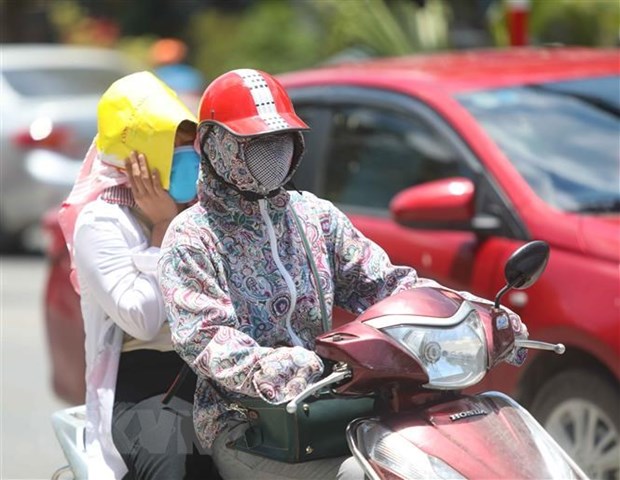 Thời điểm giữa trưa, nếu phải di chuyển trên đường, người dân cần trang bị đồ chống nắng để đảm bảo sức khỏe. (Ảnh: Thanh Tùng/TTXVN)