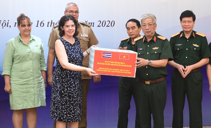 Thượng tướng Nguyễn Chí Vịnh, Thứ trưởng Quốc phòng Việt Nam trao tặng vật tư y tế phòng chống Covid-19 cho Đại sứ Cuba tại Việt Nam, bà Lianys Torres Rivera. Ảnh: Hiếu Duy.