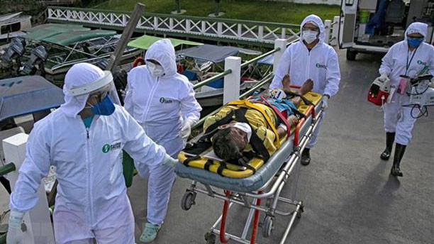 Nhân viên y tế chuyển bệnh nhân mắc Covid-19 tới bệnh viện ở Breves, Brazil. Ảnh: AFP/TTXVN)