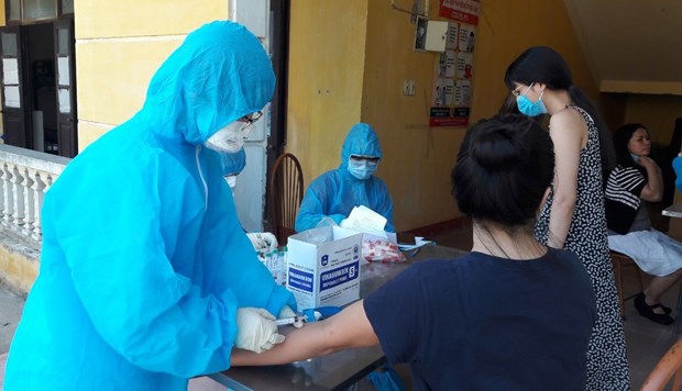 A medical worker takes a blood sample from a recently repatriated overseas Vietnamese for COVID-19 testing at a quarantine site in Ha Nam province (Photo: VNA) 