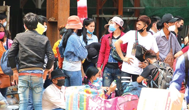 Cambodian migrant workers wait for transport upon returning from Thailand in March. (Photo: Facebook/Khmer Times)