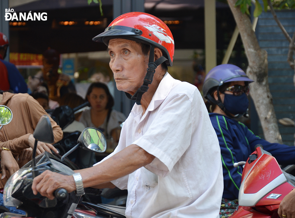 Gương mặt khá căng thẳng của một phụ huynh khi ngồi trên xe máy chờ con thi tại điểm Trường THPT Trần Phú, nằm trên địa bàn quận Hải Châu. Ảnh NGỌC PHÚ