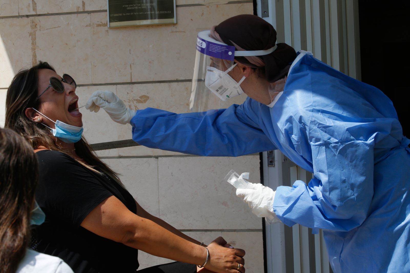  Nhân viên y tế lấy mẫu dịch xét nghiệm COVID-19 cho người dân tại Ramla, Israel, ngày 5/7/2020. Ảnh: THX/ TTXVN