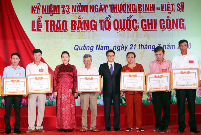 Chủ tịch Quốc hội Nguyễn Thị Kim Ngân (thứ ba, trái sang) và Phó Thủ tướng Chính phủ Vũ Đức Đam (thứ năm, trái sang) trao Bằng Tổ quốc ghi công cho gia đình các liệt sĩ. 			                  Ảnh: TTXVN