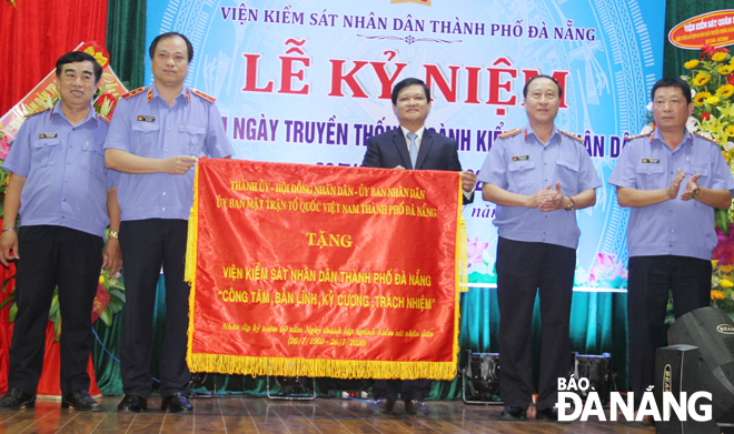 Chủ tịch HĐND thành phố Nguyễn Nho Trung (giữa) trao tặng bức trướng cho Viện Kiểm sát nhân dân thành phố. 			                    Ảnh: TRỌNG HÙNG