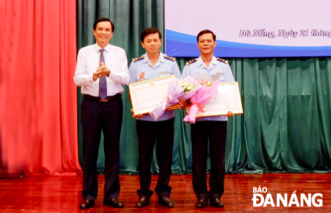 Thừa ủy quyền Chủ tịch nước, Phó Chủ tịch UBND thành phố Trần Văn Miên (trái) trao Huân chương Chiến công hạng Ba cho các tập thể, cá nhân.     	                    Ảnh: MAI QUẾ