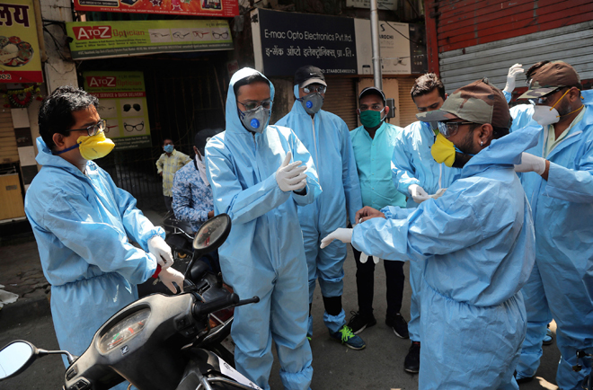 Các thành viên một tổ chức tình nguyện ở Ấn Độ chuẩn bị phát lương thực cho người dân ở Mumbai. Ảnh: AP