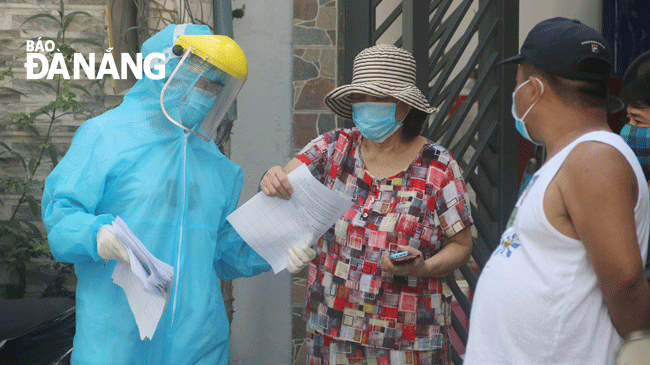 Nhân viên y tế điều tra dịch tễ, thực hiện khai báo y tế khu vực dân cư nơi bệnh nhân 418 sinh sống. Ảnh: PHAN CHUNG