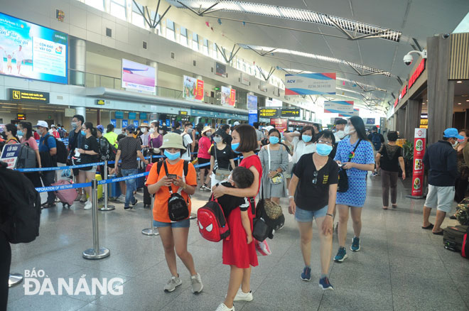 Hành khách rời Đà Nẵng một cách trật tự tại Cngr hàng không quốc tế Đà Nẵng (Ảnh chụp 15h ngày 26-7). Ảnh: THÀNH LÂN