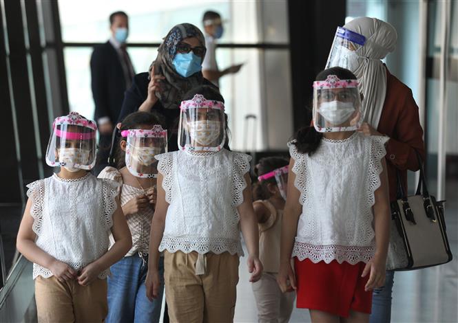 Một gia đình người Iraq đeo khẩu trang và tấm chắn che mặt để phòng lây nhiễm COVID-19 tại sân bay quốc tế ở Baghdad, ngày 23/7. Ảnh: AFP/TTXVN