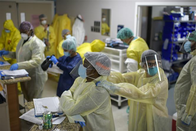 Nhân viên y tế mặc trang phục bảo hộ trước khi điều trị cho bệnh nhân nhiễm COVID-19 tại Houston, Texas, Mỹ. Ảnh: AFP/TTXVN