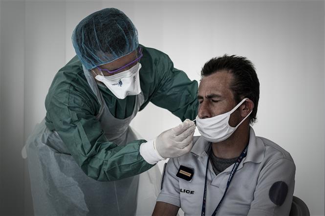 Nhân viên y tế lấy mẫu dịch xét nghiệm COVID-19 cho người dân tại Merignac, Pháp ngày 23/7/2020. Ảnh: AFP/TTXVN