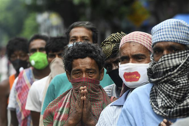 Người vô gia cư xếp hàng chờ nhận bữa ăn miễn phí tại Kolkata, Ấn Độ, ngày 25/7/2020. Ảnh: AFP/TTXVN