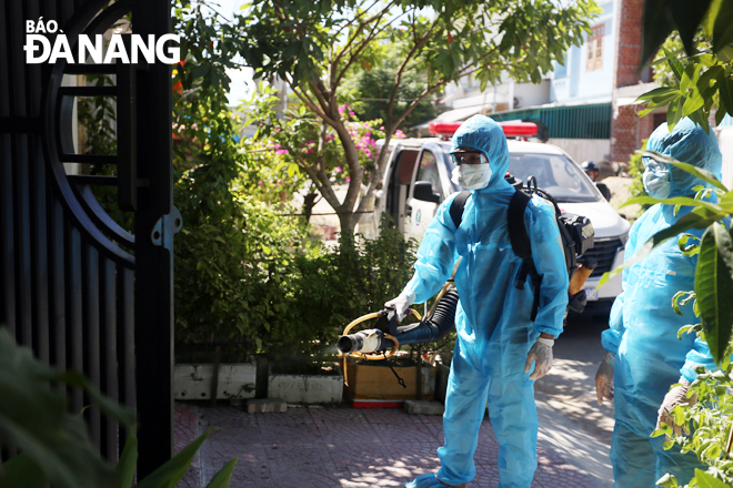 Lực lượng y tế phun hóa chất khử trùng tại nơi bệnh nhân 416 cư trú. Ảnh: PHAN CHUNG