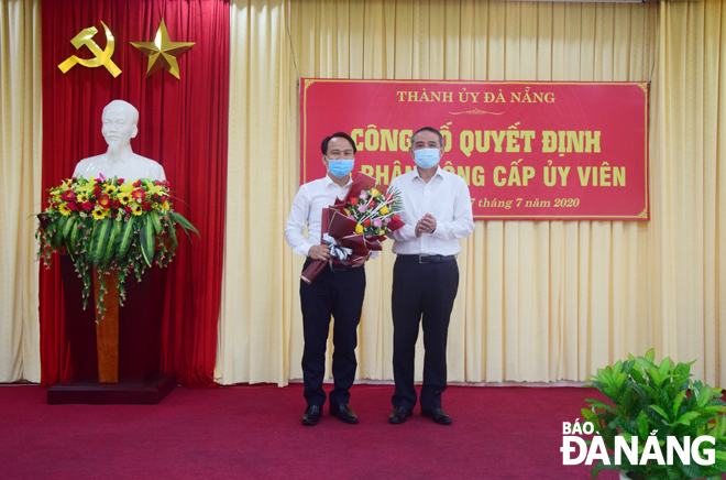 Bí thư Thành ủy Trương Quang Nghĩa trao quyết định, tặng hoa chúc mừng ông Nguyễn Đình Vĩnh. Ảnh: T. HUY