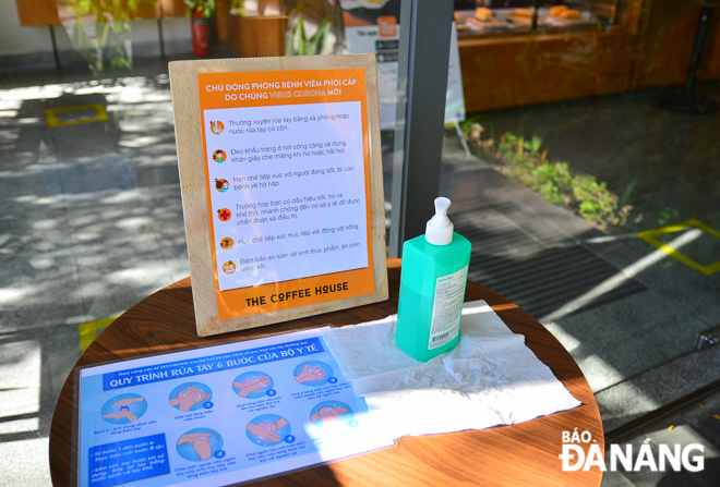 A café recommends its guest to wash their hands with alcohol-based hand sanitizer before entering the shop in order to cut down on germs