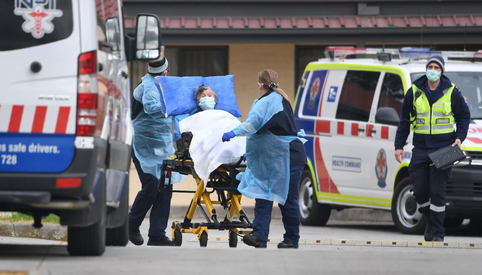 Nhân viên y tế chuyển bệnh nhân nghi mắc COVID-19 lên xe cứu thương tại bang Victoria, Australia ngày 27/7/2020. Ảnh: AFP/TTXVN