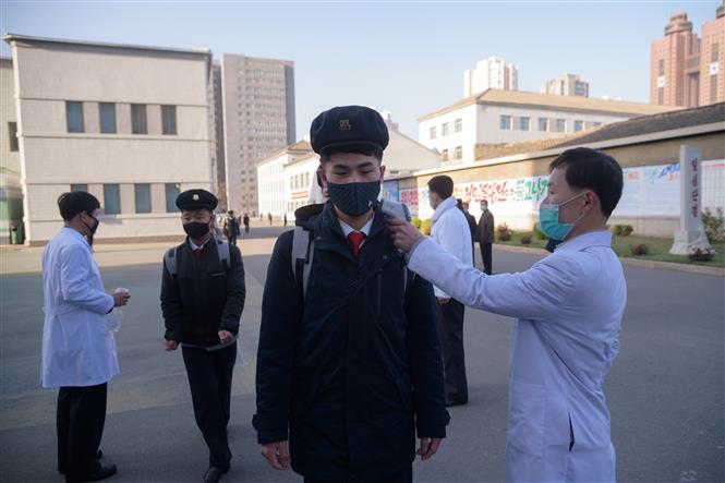 Kiểm tra thân nhiệt phòng lây nhiễm COVID-19 tại trường đại học Y ở Bình Nhưỡng, Triều Tiên. Ảnh: AFP/TTXVN