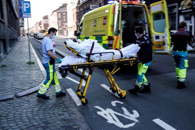 Nhân viên y tế chuyển bệnh nhân mắc COVID-19 lên xe cứu thương tại Liege, Bỉ ngày 10/4/2020. Ảnh: AFP/TTXVN