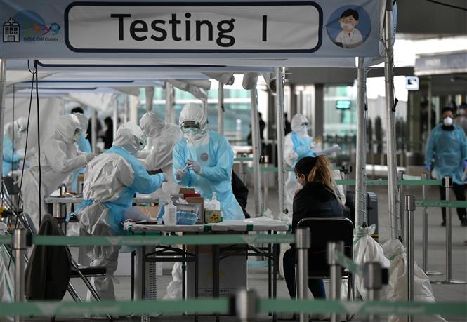 Nhân viên y tế lấy mẫu dịch xét nghiệm COVID-19 cho hành khách tại sân bay quốc tế Incheon, phía tây thủ đô Seoul, Hàn Quốc. Ảnh: AFP/ TTXVN