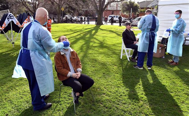 Nhân viên y tế lấy mẫu dịch xét nghiệm COVID-19 cho người dân tại Melbourne, bang Victoria, Australia ngày 1/7/2020. Ảnh: AFP/TTXVN