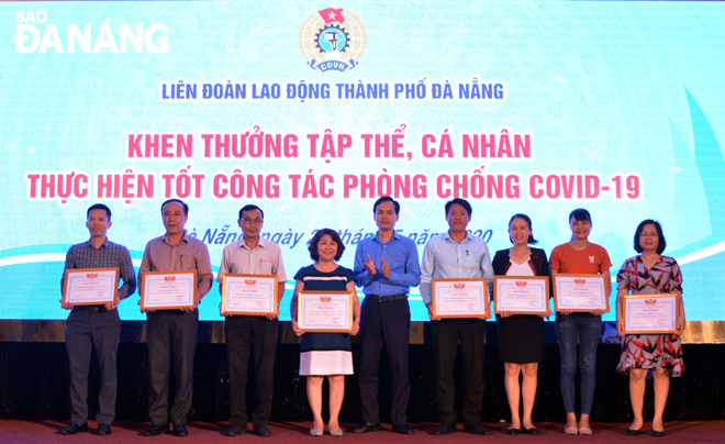 Chủ tịch LĐLĐ thành phố Nguyễn Duy Minh (giữa) trao Bằng khen của Tổng LĐLĐ Việt Nam và LĐLĐ thành phố cho các tập thể, cá nhân có thành tích xuất sắc trong công tác phòng, chống Covid-19.  Ảnh: NGỌC YẾN