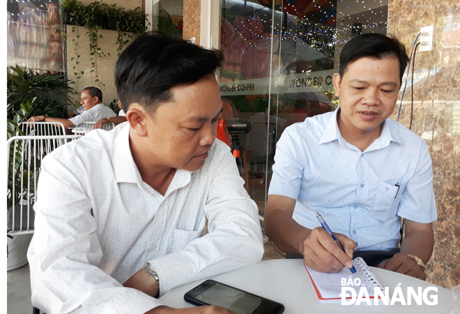 Phó Chủ tịch UBND xã Hòa Sơn Hồ Văn Y (bên trái) trao đổi công việc với trưởng thôn An Ngãi Tây 1 Chế Viết Chiến Thắng. Ảnh: TRỌNG HÙNG
