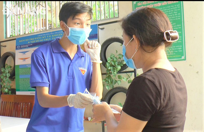 A YU member in Hai Chau District Hoa Thuan Dong Ward instructing a local resident how to wear face coverings and wash hands safely