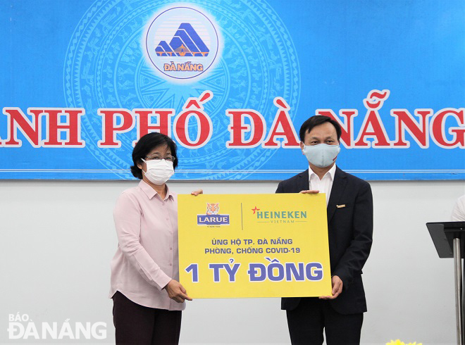 Chủ tịch Ủy ban MTTQ Việt Nam thành phố Đặng Thị Kim Liên (trái) tiếp nhận ủng hộ từ Công ty TNHH Nhà máy bia Heineken Việt Nam - Đà Nẵng. Ảnh: L.P