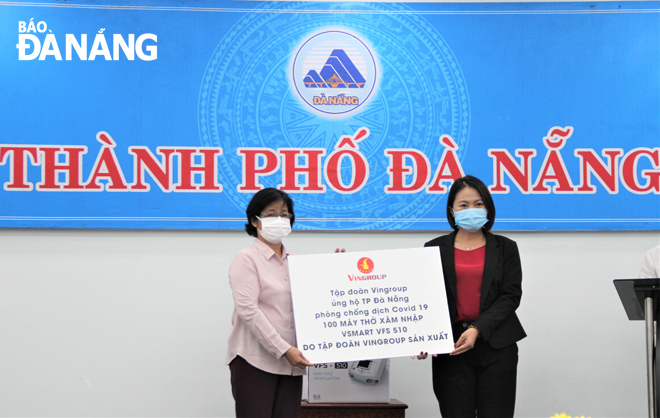 Chủ tịch Ủy ban MTTQ Việt Nam thành phố Đặng Thị Kim Liên (trái) tiếp nhận 100 máy xâm nhập thở VFS 510 từ Tập đoàn Vingroup. 			Ảnh: LAM PHƯƠNG