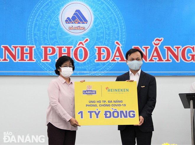 Municipal Fatherland Front Committee Chairwoman Dang Thi Kim Lien (left) receiving financial support from the Vietnam Brewery – Da Nang Limited Company