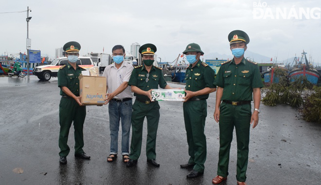 Lãnh đạo Đồn Biên phòng Sơn Trà tặng quà cho lực lượng chốt trực phòng chống dịch tại khu vực cảng cá và chợ đầ mối thủy sản Thọ Quang. Ảnh: HOÀNG HIỆP 