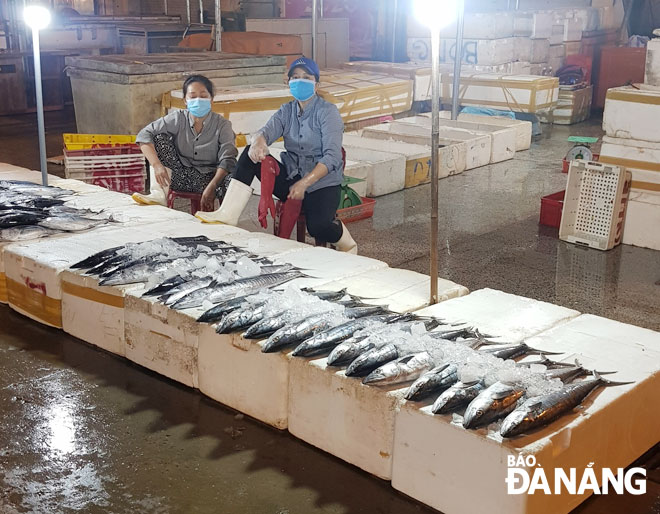 Các tiểu thương tại cảng cá Thọ Quang đều thực hiện đeo khẩu trang theo đúng quy định (ảnh chụp đêm 2-8). Ảnh: LÂM MAI