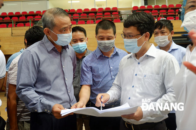 Đồng chí Trương Quang Nghĩa (trái) kiểm tra tiến độ xây dựng Bệnh viện dã chiến sáng 2-8. Ảnh: PHAN CHUNG