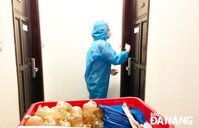 Nhân viên y tế mang cơm đến từng phòng cho các bệnh nhân khoa Thận nhân tạo đang cách ly tập trung tại khách sạn trên địa bàn quận Sơn Trà. Ảnh: XUÂN DŨNG	