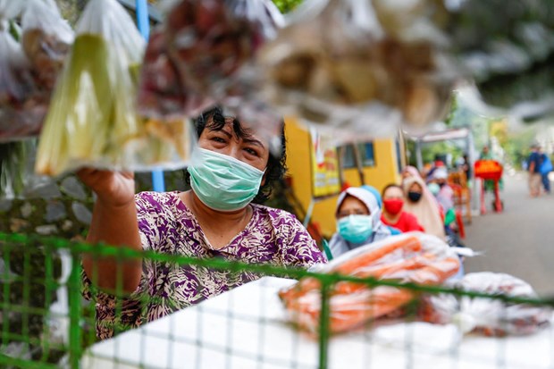 People practice social distancing while buying vegetables amid the COVID-19 outbreak in Depok, West Java, on April 28. (Source: Reuters)