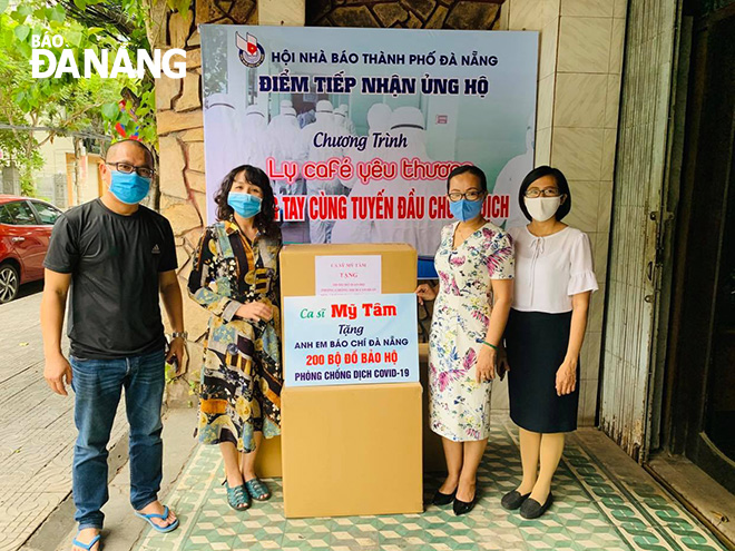 On behalf of the local journalists, representatives from the municipal Department of Information and Communications (right) and the city’s Journalists’ Association (left) receiving the donations from singer My Tam