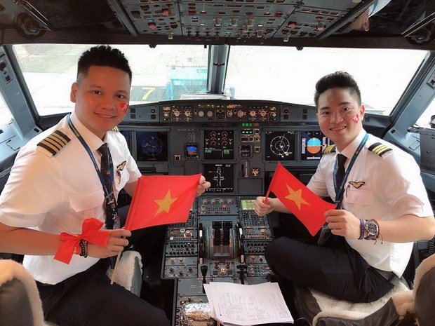 Nghia (R) flew an additional trip conducted by Vietnam Airlines to take football fans to Malaysia to watch a match at the AFF Suzuki Cup in 2018 (Photo courtesy of the pilot)