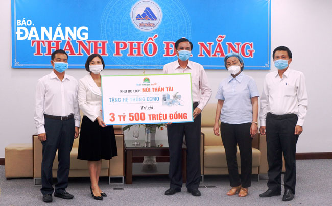 Municipal People’s Committee Vice Chairman Tran Van Mien (third, right) chairing the reception of the ECMO machine worth 3.5 billion VND donated by the DHC Suoi Doi Corporation