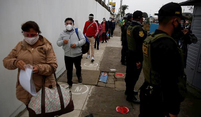 Hành khách thực hiện quy tắc giãn cách xã hội tại sân bay ở Lima, Peru. Ảnh: Reuters