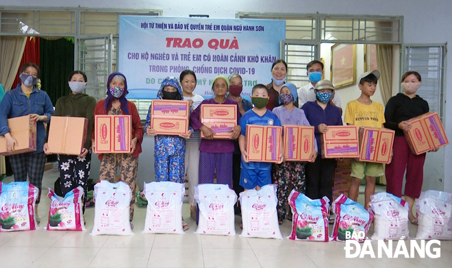 Hội Từ thiện và Bảo vệ quyền trẻ em quận Ngũ Hành Sơn và đơn vị tài trợ tặng quà cho người nghèo bị ảnh hưởng Covid-19. 				Ảnh: THANH LONG