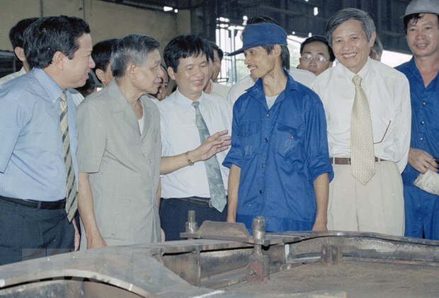 Tổng Bí thư Lê Khả Phiêu (thứ hai, trái sang) thăm hỏi công nhân phân xưởng đóng mới nhà máy xe lửa Gia Lâm, ngày 27-8-2000. Ảnh: TTXVN