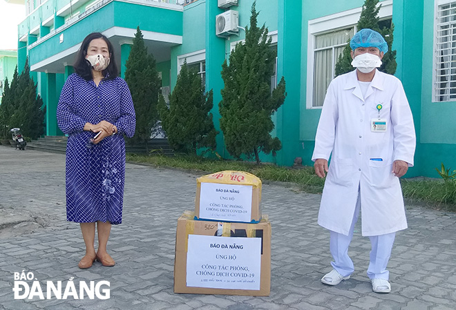 Deputy Editor-in-Chief of the Da Nang Newspaper Tran Thi Thu Thuy (left) presenting medical protective items to the city’s blockaded Lung Hospital