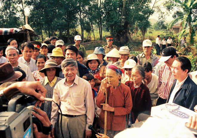 Tổng Bí thư Lê Khả Phiêu thăm hỏi người dân xã Hòa Phú, huyện Hòa Vang sau trận lũ quét lịch sử năm 1999.  Ảnh: Nhân Mùi