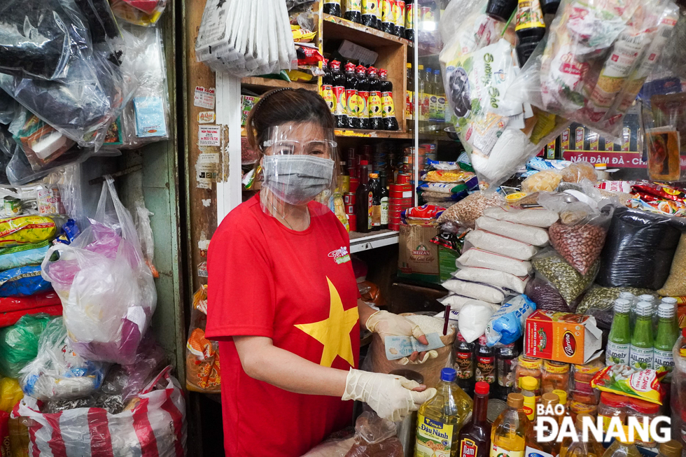 A market stallholder at the Dong Da Market wearing such protective items as face shield, surgical mask and gloves to low the spread of the virus