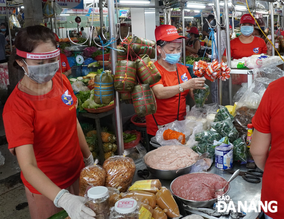 Market stallholders using face shields highlighting  the words “Joining hands to repel Covid-19”