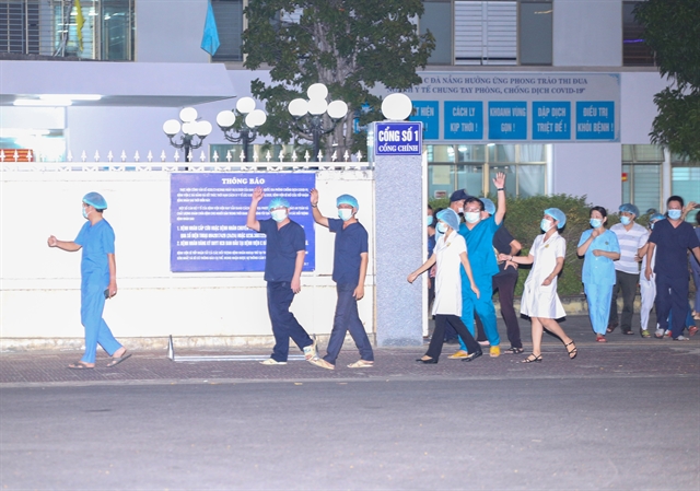 Doctors and nurses walk through entrance of the C Hospital in Da Nang after lockdown was lifted