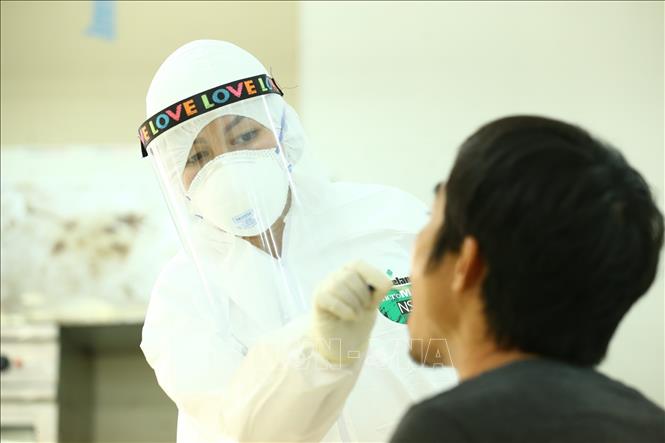 Nhân viên y tế lấy mẫu dịch hầu họng để xét nghiệm bằng phương pháp RT-PCR cho người dân phường Đội Cấn (Ba Đình, Hà Nội) về từ Đà Nẵng, ngày 9/8/2020. Ảnh: Minh Quyết/TTXVN